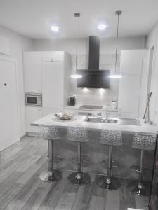 马德里Apartamento estilo nórdico en Malasaña (Madrid Centro)的厨房配有水槽和带凳子的台面