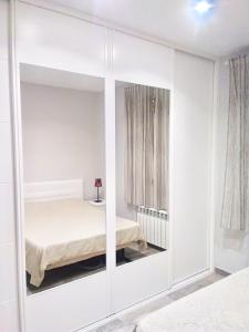 马德里Apartamento estilo nórdico en Malasaña (Madrid Centro)的卧室配有白色衣柜和床