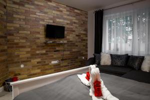 久洛Liget Apartman的带沙发和砖墙的客厅
