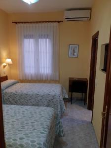 马德里安吉丽纳旅馆的酒店客房设有两张床和窗户。