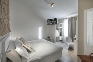 TaverneCP Resort的白色卧室设有一张床和墙上的电视