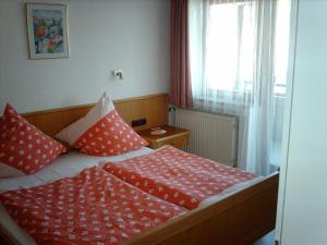 奥伯约赫Haus Marianne的一间卧室配有红色和白色枕头的床