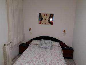 马德里安吉丽纳旅馆的卧室配有一张床,墙上挂着一幅画