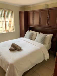 克莱克斯多普Villa de la Rosa Klerksdorp的卧室配有一张白色大床和两条毛巾