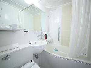 古河市APA Hotel Ibaraki Koga Ekimae的白色的浴室设有水槽和浴缸。