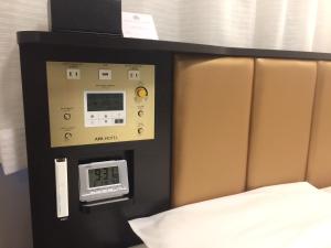 古河市APA Hotel Ibaraki Koga Ekimae的一间设有一张床和墙上一个时钟的房间