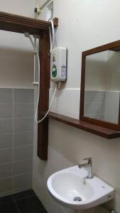 瓜拉大汉Naura Roomstay的浴室设有白色水槽和镜子
