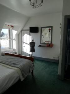 托明陶尔Argyle Guest House的一间卧室配有一张床、一个梳妆台和一扇窗户。