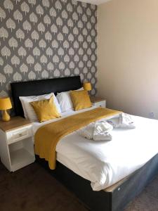 Minworth明维斯酒店的一间卧室配有一张带黄色枕头的大床