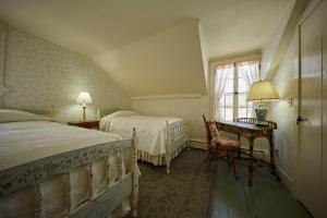 斯托克布里奇红狮旅馆的一间卧室设有两张床、一张桌子和一个窗口。
