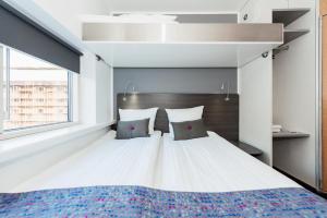 哥本哈根斯堪的纳维亚卡宾酒店的卧室配有一张带两个枕头的大白色床