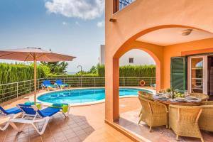 卡拉加尔达纳Villa Marcolis Mar的一个带桌椅的庭院和一个游泳池