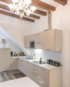 威尼斯Doge's House的厨房配有白色橱柜和吊灯。