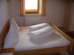 索尔登比肯海姆旅馆的一张带两个白色枕头的床和窗户