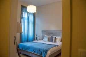 波尔图Sweet Swell的一间卧室配有一张带蓝色床单的床和一扇窗户。