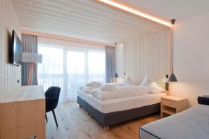 塞尔瓦迪加尔代纳山谷Hotel Garni Broi - Charme & Relax的酒店客房设有两张床和大窗户。