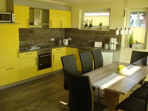 费马恩Ferienhaus Seeschwalbe的厨房配有木桌和黄色橱柜。