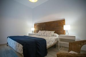 马拉加大教堂公寓的一间卧室配有一张带木制床头板的床