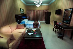 达曼Ramada by Wyndham Dammam Khaleej Road的酒店客房配有床、沙发和桌子。