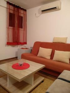 波德戈里察Apartments Popovic的客厅配有红色沙发和茶几