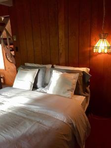 梅戈格Le Rustique Orford Domaine Cheribourg的卧室配有一张带白色床单和枕头的大床。