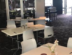 纽卡斯尔布罗德米德尊享酒店的用餐室配有白色的桌子和白色的椅子