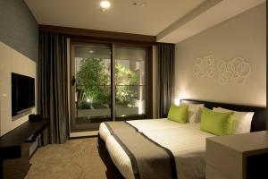 东京东急二子玉川卓越大酒店的一间卧室配有一张带绿色枕头的床和一扇窗户
