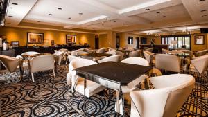 盐湖城最佳西方机场套房旅馆的一间酒吧,房间内设有白色的椅子和桌子
