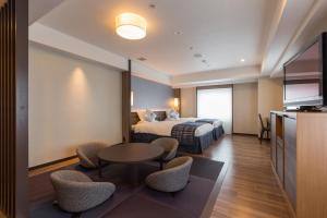 松江市松江东优美好酒店的酒店客房带一张床、一张桌子和椅子