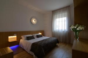 马泰拉圣多梅尼科艺术酒店的一间卧室,配有一张床和花瓶