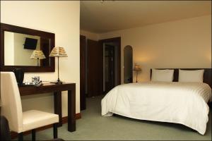 克利夫登全双旅馆的一间卧室配有一张床、一张桌子和一把椅子