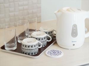读谷村Condominium・yuyuki的厨房柜台配有咖啡壶和杯子
