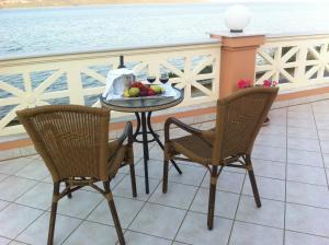 尼基亚娜佛罗雷纳酒店的阳台上的桌子和两把椅子以及一碗水果