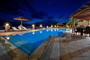 伊奥斯乔拉赫尔墨斯旅馆的夜间游泳池,配有椅子和遮阳伞