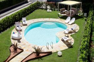波里奥特米Hotel Brescia & Apartments的享有带椅子和桌子的游泳池的顶部景致