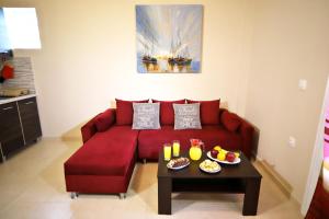 科孚镇Luna Bianca - Corfu Apartments的客厅里一张红色的沙发,配有桌子