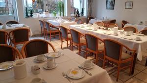 Salzkotten瓦尔茨酒店的用餐室配有桌椅和白色的桌布