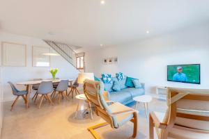穆罗海滩Beachfront Villa Socias Playa的客厅配有蓝色的沙发和桌子