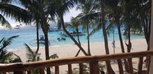 长滩岛戴夫咕噜长滩岛海滩度假酒店的棕榈树和水中船只的海滩