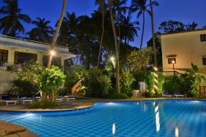 帕纳吉O Pescador an Indy Resort的夜间在房子前面的游泳池