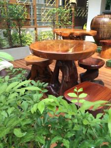曼谷Kim Hotel At Morleng的花园里的木桌和凳子