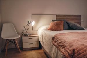 阿斯佩蒂亚Apartamento Erdi Kale的一间卧室配有一张床、一把椅子和一盏灯