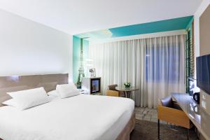 巴黎巴黎十五区凡尔赛门美居酒店的酒店客房设有一张大床和一台电视。