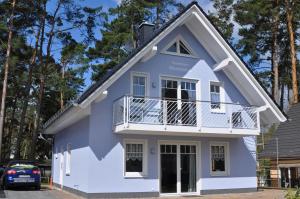 马林费尔德Ferienhaus Müritzidyll / EG-Appartement的蓝色和白色的房子设有阳台