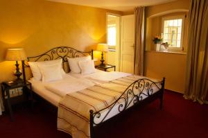 帕德博恩加勒里酒店的卧室配有一张带白色床单和枕头的大床。