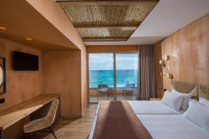 赫索尼索斯Palmera Beach Hotel & Spa - Adults Only的酒店客房设有一张床,享有海景。