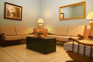 马德里加泰罗尼亚旅馆的客厅设有两张沙发和一张鲜花桌