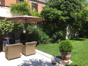 威尼斯Primaluce的庭院里设有带椅子和遮阳伞的庭院。