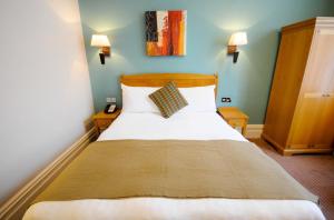伯恩茅斯杜丽酒店的一间卧室配有带白色床单和枕头的床。