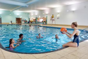 斯凯格内斯南部风景公园酒店的一名女子在游泳池里玩球